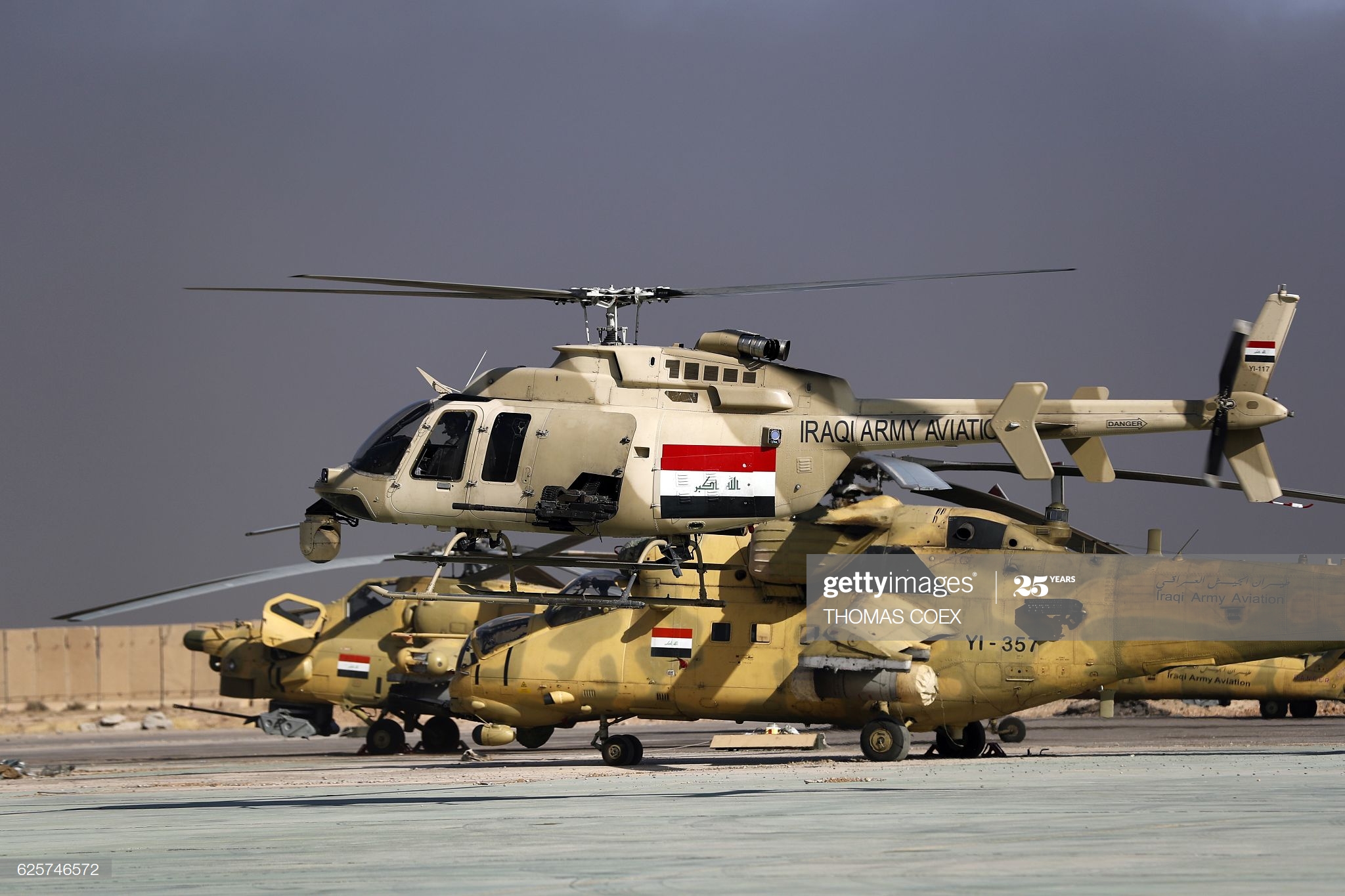 an-iraqi-airforce-bell-407-helicopter-takes-off-in-front-of-mi35-and-picture-id625746572
