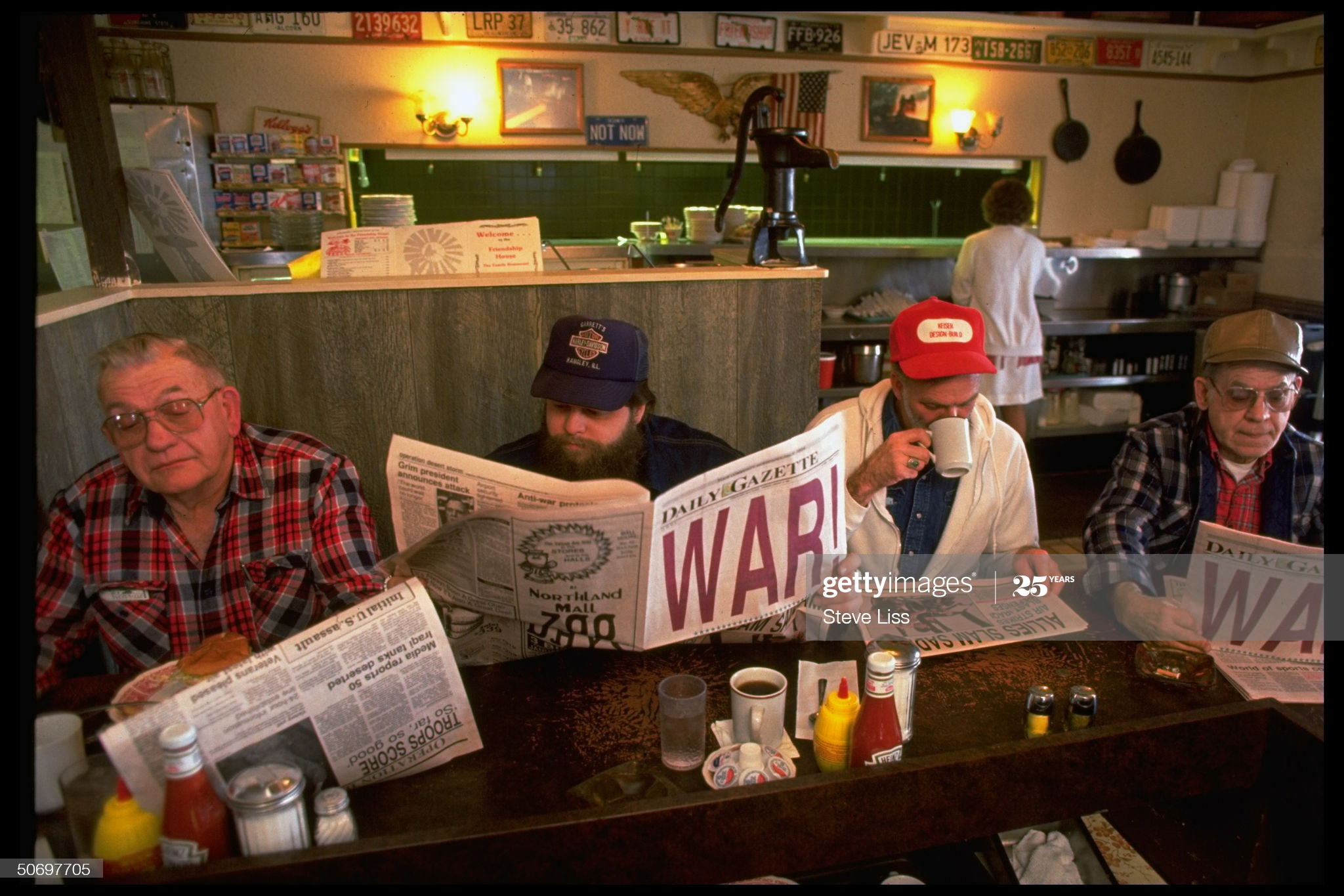 men-reading-local-daily-gazette-newspaper-w-healine-war-at-friendship-picture-id50697705