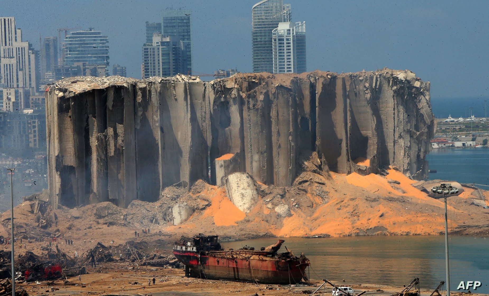 (FILES) This file photo taken on August 5, 2020, shows the damaged grain silos and a burnt boat at Beirut's harbour, a day…