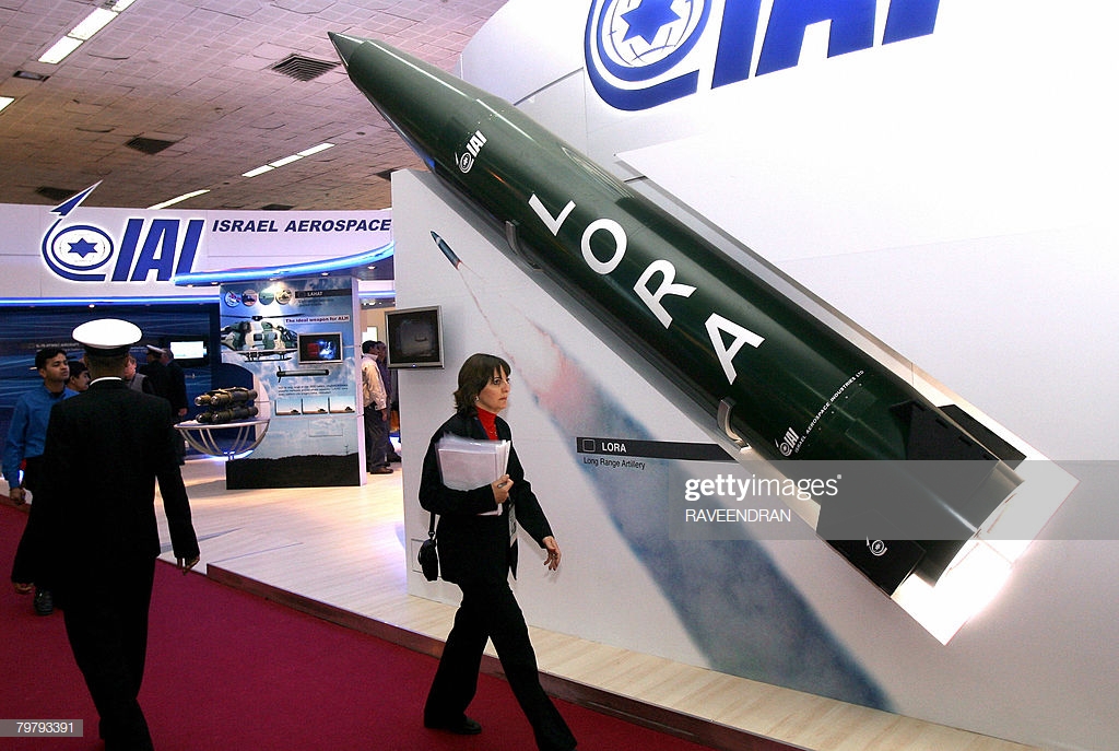 woman-walks-past-a-model-of-a-lora-missile-israels-long-range-at-picture-id79793391