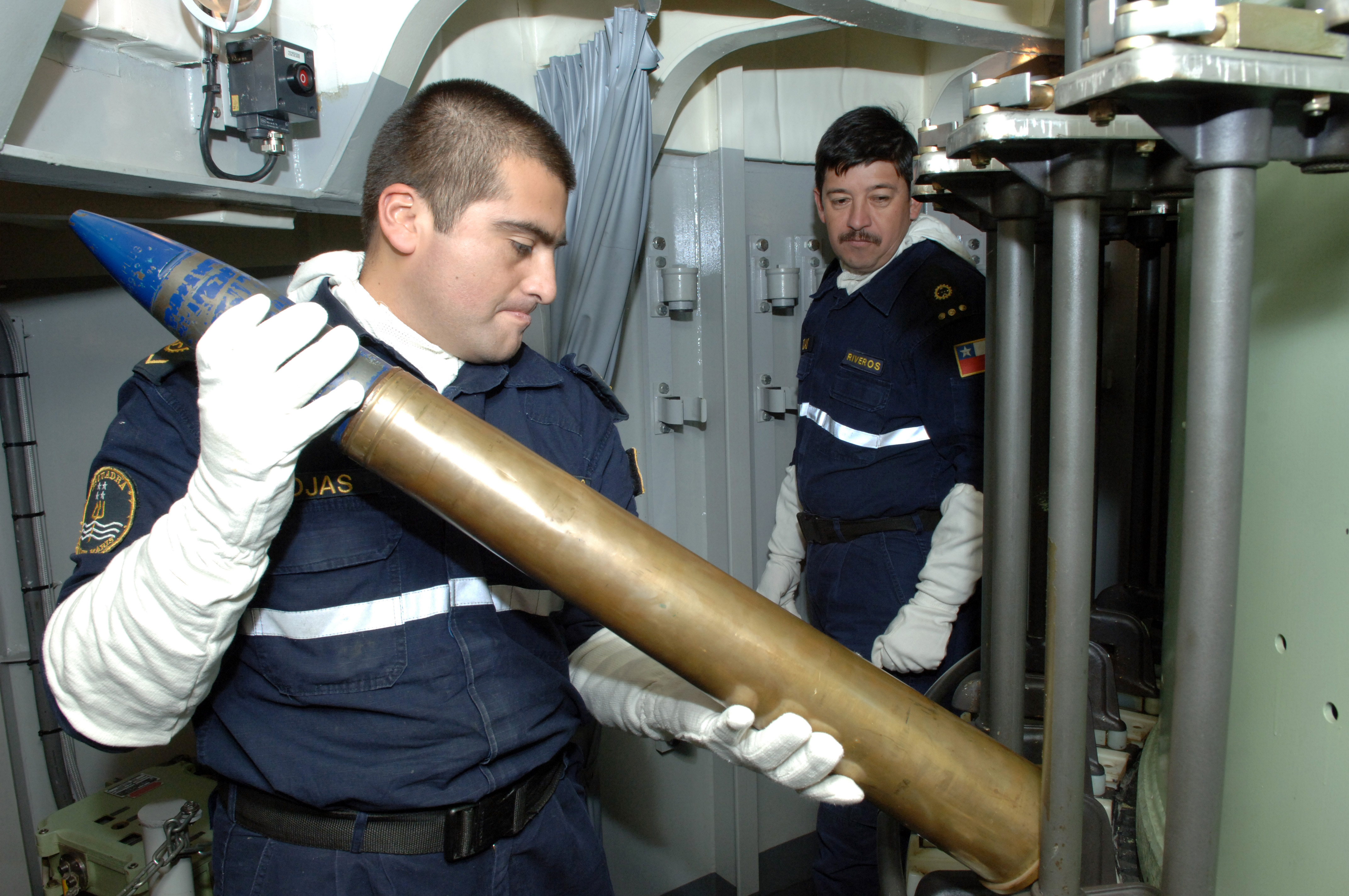 US_Navy_080720-N-3931M-078_Cpl._Boris_Rojas_loads_an_ammunition_into_the_magazine_of_a_76_mm_gun_aboard_the_Chilean_navy_frigate_CS_Riveros_(FF18)_during_a_Rim_of_the_Pacific_(RIMPAC)_2008_exercise_off_the_coast_of_Hawaii.jpg