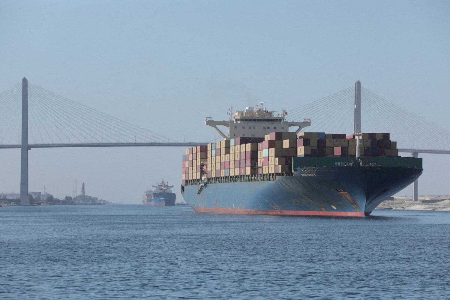 سفينة حاويات بالقرب من جسر قناة السويس المعروف باسم «جسر السلام» (هيئة قناة السويس - رويترز)