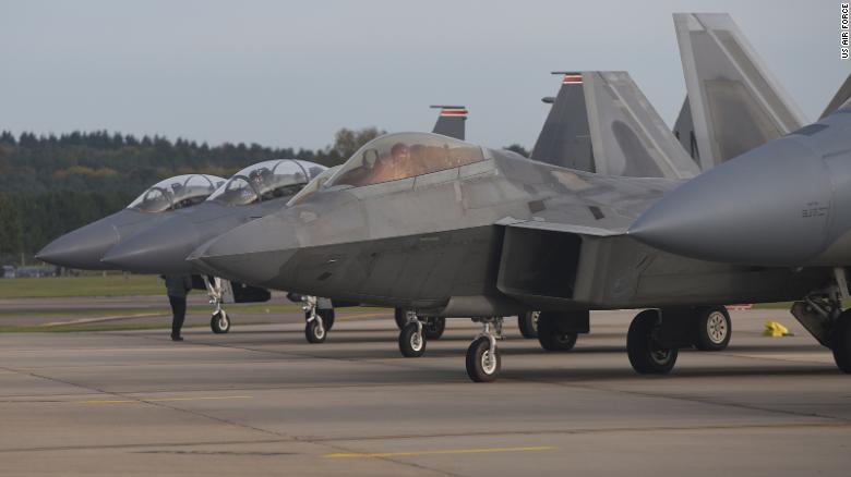 تصطف طائرة F-22 Raptor التابعة للقوات الجوية الأمريكية بجوار ثلاث طائرات F-15E Strike Eagles في سلاح الجو الملكي Lakenheath ، إنجلترا ، في عام 2017. 