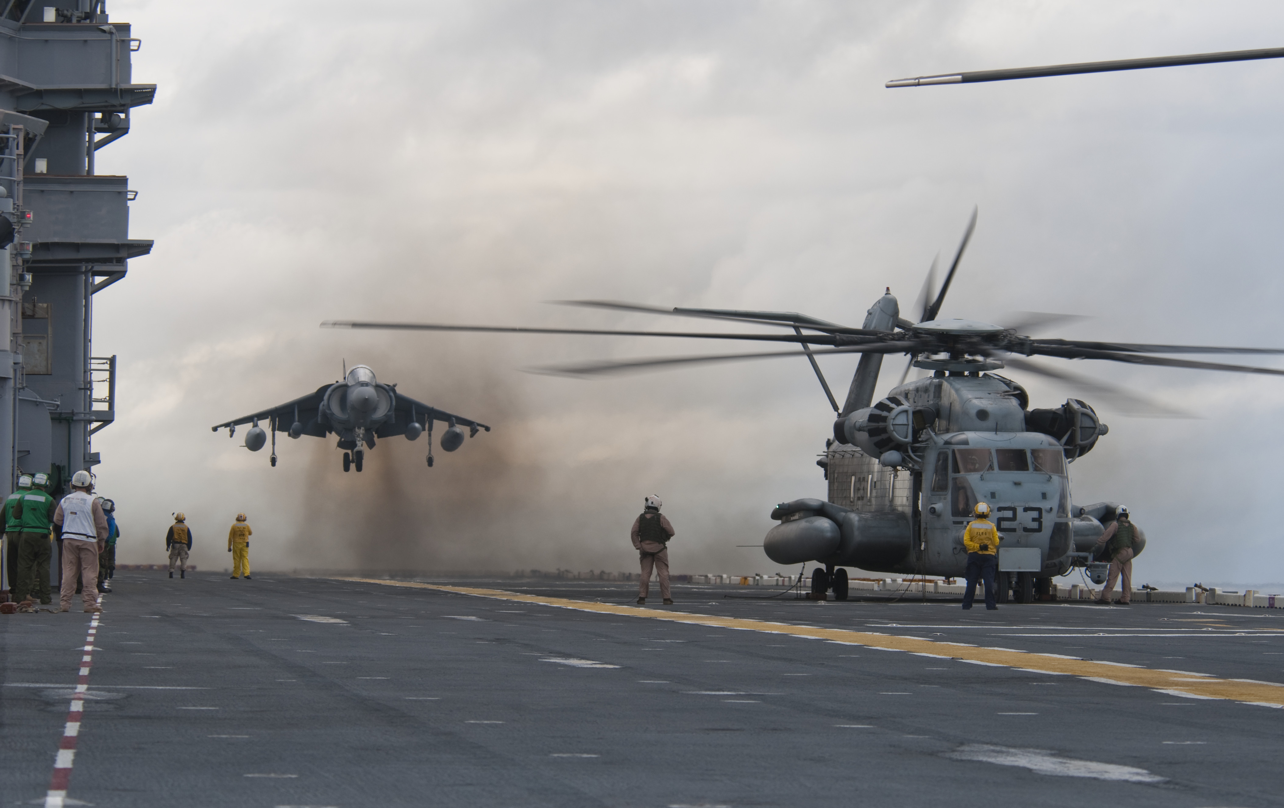 US_Navy_091026-N-5319A-025_An_AV-8_Harrier_from_Marine_Attack_Squadron_(VMA)_223_lands_next_to_an_MH-53E_Sea_Dragon_helicopter_aboard_the_amphibious_assault_ship_USS_Nassau_(LHA_4)_during_flight_operations.jpg