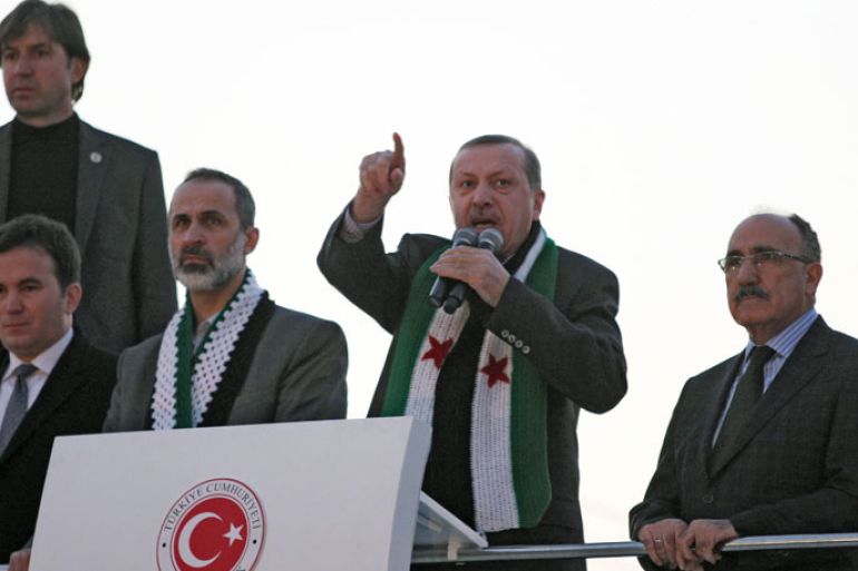 Turkish Prime Minister Recep Tayyip Erdogan (2ndR) flanked by with President of the National Coalition for Syrian Revolutionary and Opposition Forces Ahmed Moaz al-Khatib (3rdR) speaks to the audience during a meeting at Akcakale Refugee camp on December 30, 2012, in Urfa. International peace envoy for Syria Lakhdar Brahimi warned that the Syrian war was worsening by the day as he announced a peace plan he believed could find support from world powers, including key Syria ally, Russia. AFP PHOTO/STR