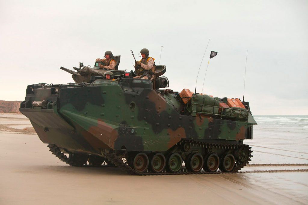 مشاة البحرية يقودون مركبة هجومية برمائية من طراز AAV7 على الشاطئ.
