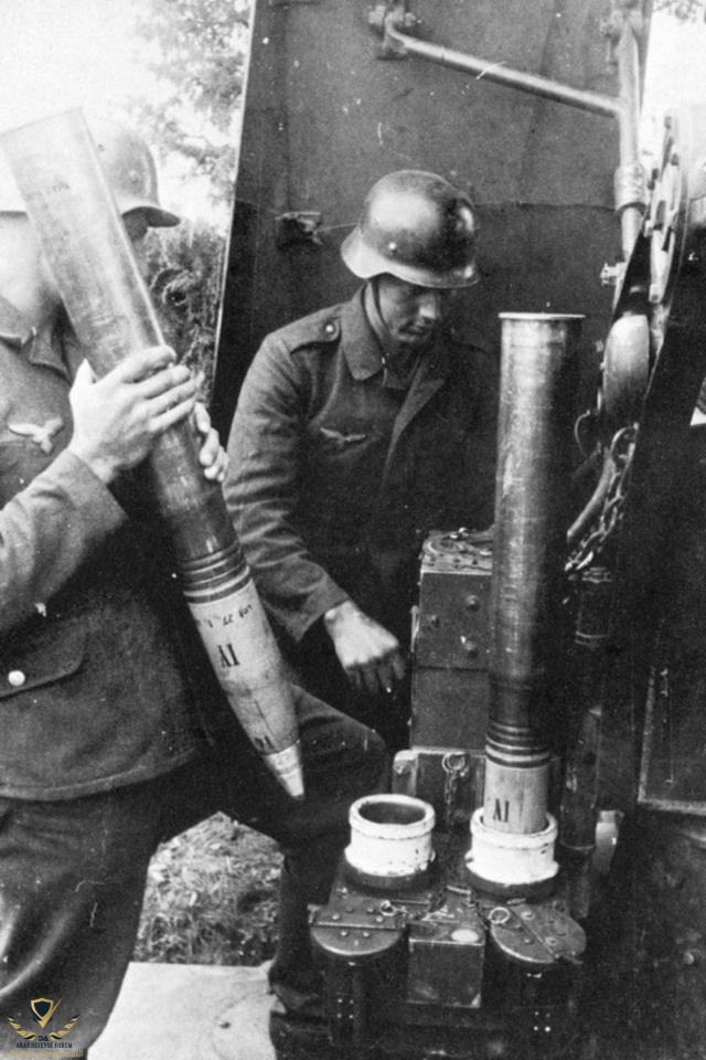 German FlaK gunners insert 88mm shells into a machine which determines the burst altitude, c.1...jpg