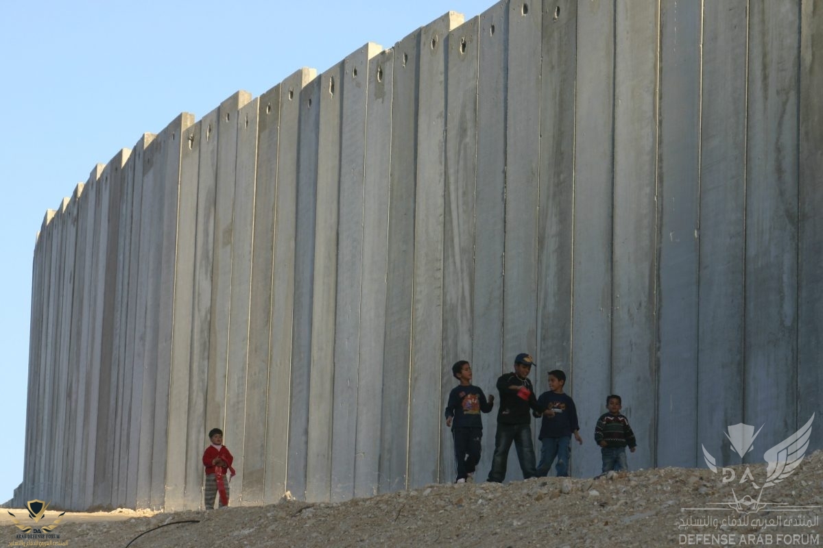 Palestinian-children-playing-near-a-high-wall-that-separates-their-residence-wih-Israeli-settl...jpg