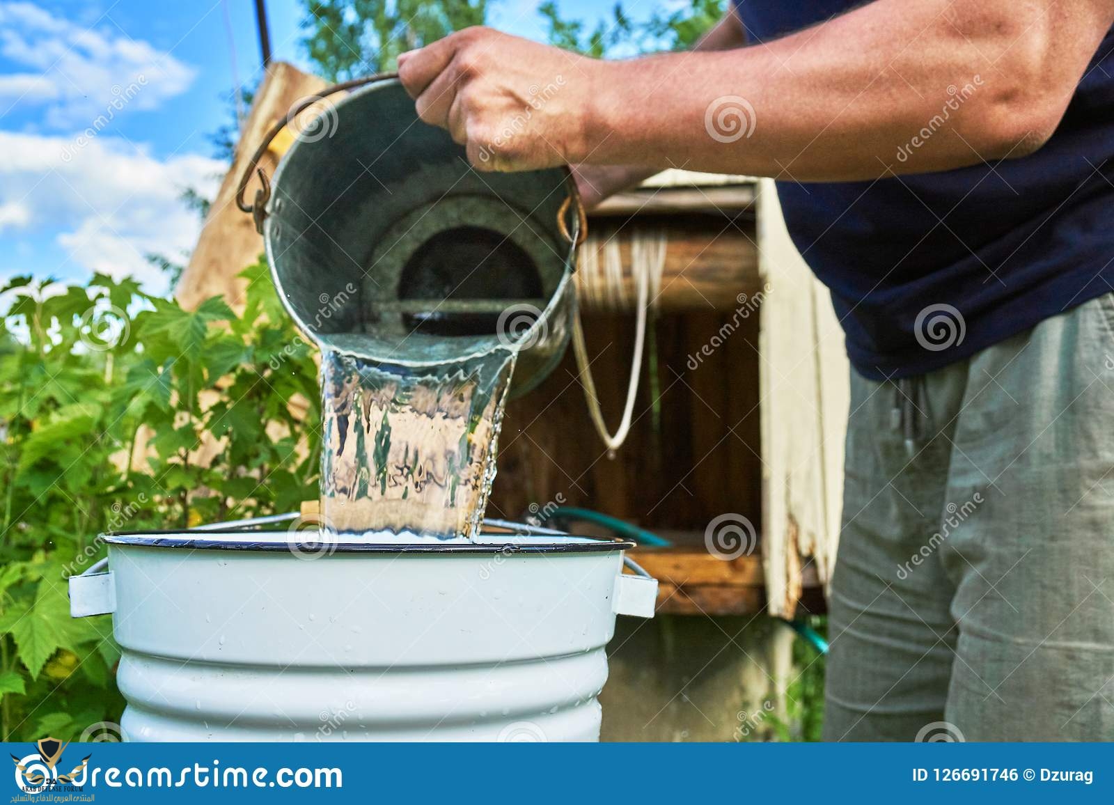 man-pouring-water-just-taken-up-well-enameled-bucket-man-pouring-water-just-taken-up-well-enam...jpg