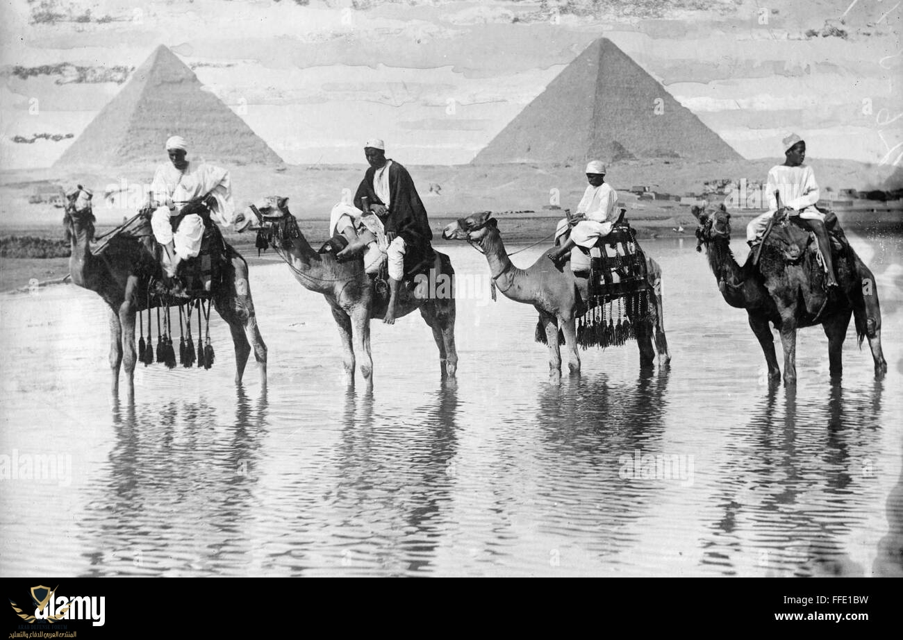 egypt-caravan-nmen-riding-camels-along-the-nile-river-in-giza-egypt-FFE1BW.jpg