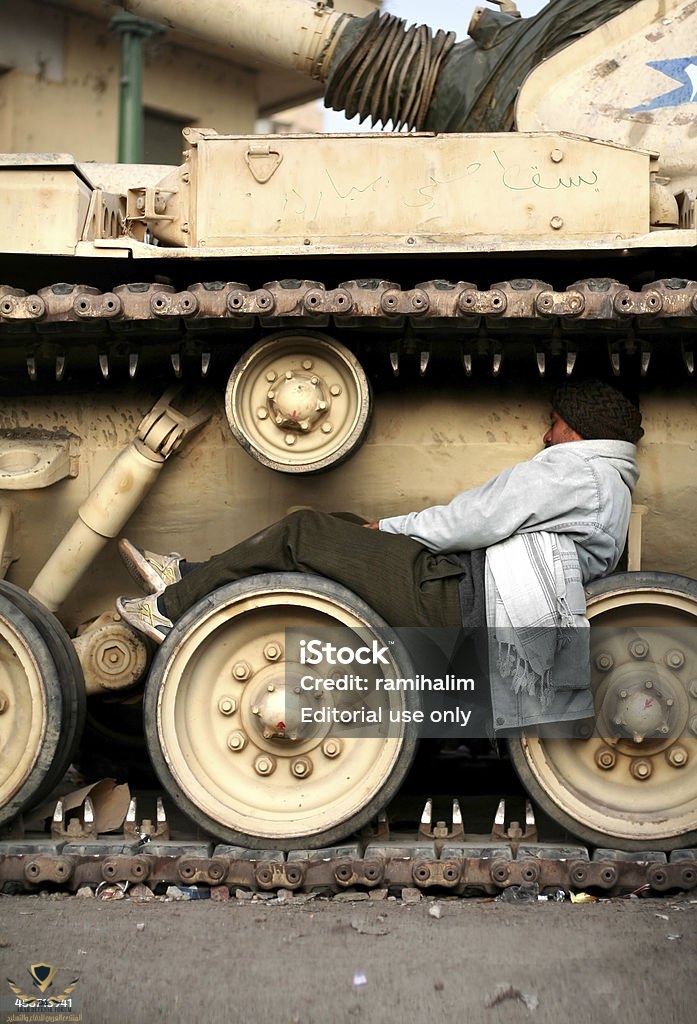 tired-man-sleeping-on-tank-wheels-egypt-2011-revolution.jpg