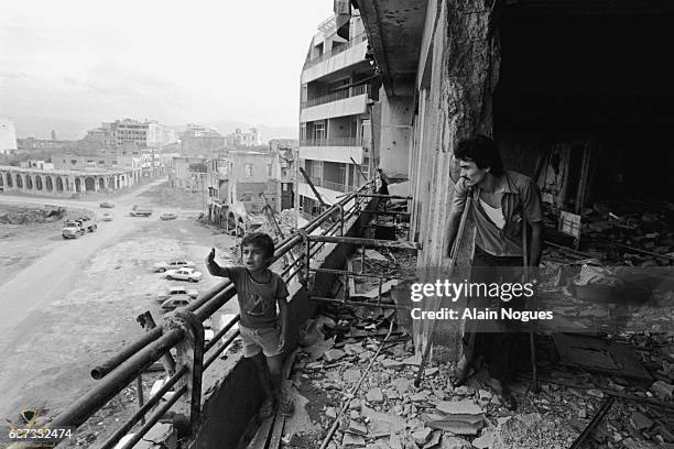 a-young-boy-and-his-wounded-father-inspect-the-bombed-out-shell-of-their-apartment-in-beirut.jpg