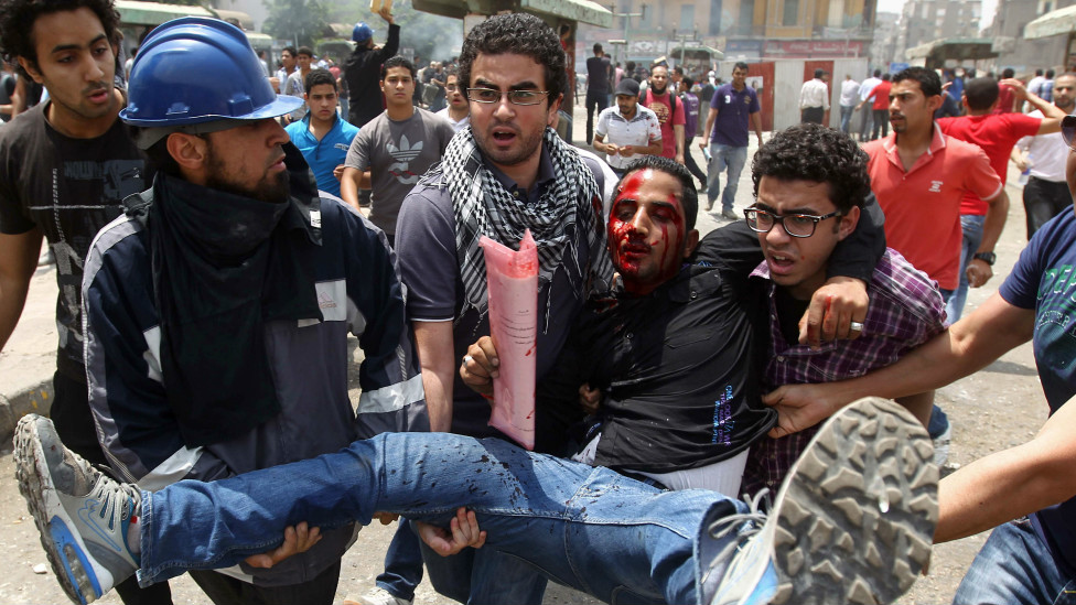 120502214120_egyptian_anti-military_protesters_evacuate_a_demonstrator__976x549_afp_nocredit.jpg