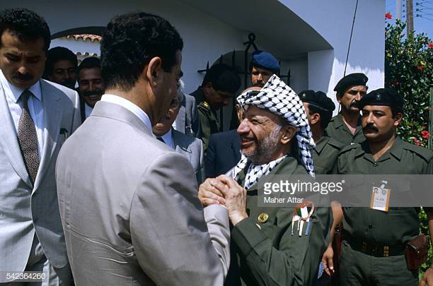 yasser-arafat-welcomes-iraqs-president-saddam-hussein-to-his-villa-picture-id542364260