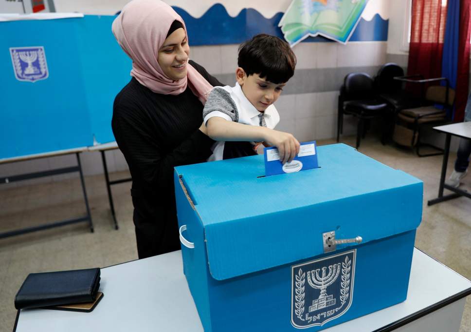 An-Israeli-Arab-citizen-from-Taiybe-town-casts-her-ballot-together-with-her-son-at-a-polling-station.jpg