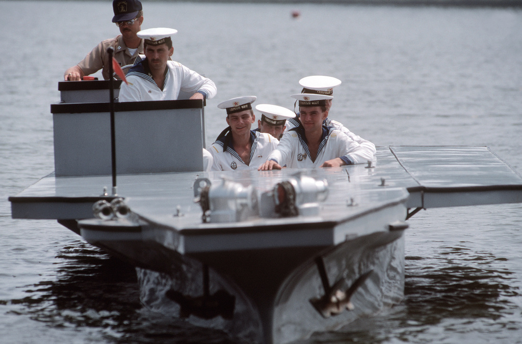 With a US Navy lieutenant at the helm, five Soviet Sailors enjoy a ride in a miniature aircraft carrier during their visit to the base.  In Norfolk for a five-day goodwill visit are the Guided Missile Cruiser MARSHAL USTINOV (CG 088), the Guided Missile Destroyer OTLICHNYY (DDG 434) and the Replenishment Oiler GENRIKH GASANOV.  This is the first time that ships of the Soviet navy have visited an American military port