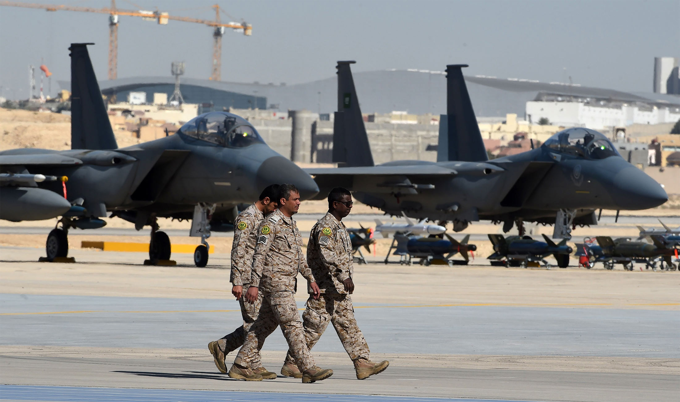 Saudi army officers walk past F-15 fighter jets, GBU bombs and missiles displayed during a ceremony marking the 50th anniversary of the creation of the King Faisal Air Academy at King Salman airbase in Riyadh on January 25, 2017