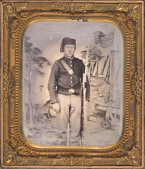 <p>مرتديًا طربوشًا زوافيًا ومجهزًا بحربة سيف على طراز زوافي عام 1862، وقف هذا الجندي المجهول الهوية من الاتحاد لالتقاط صورة شخصية على خلفية تصور معسكرًا عسكريًا للاتحاد</p>