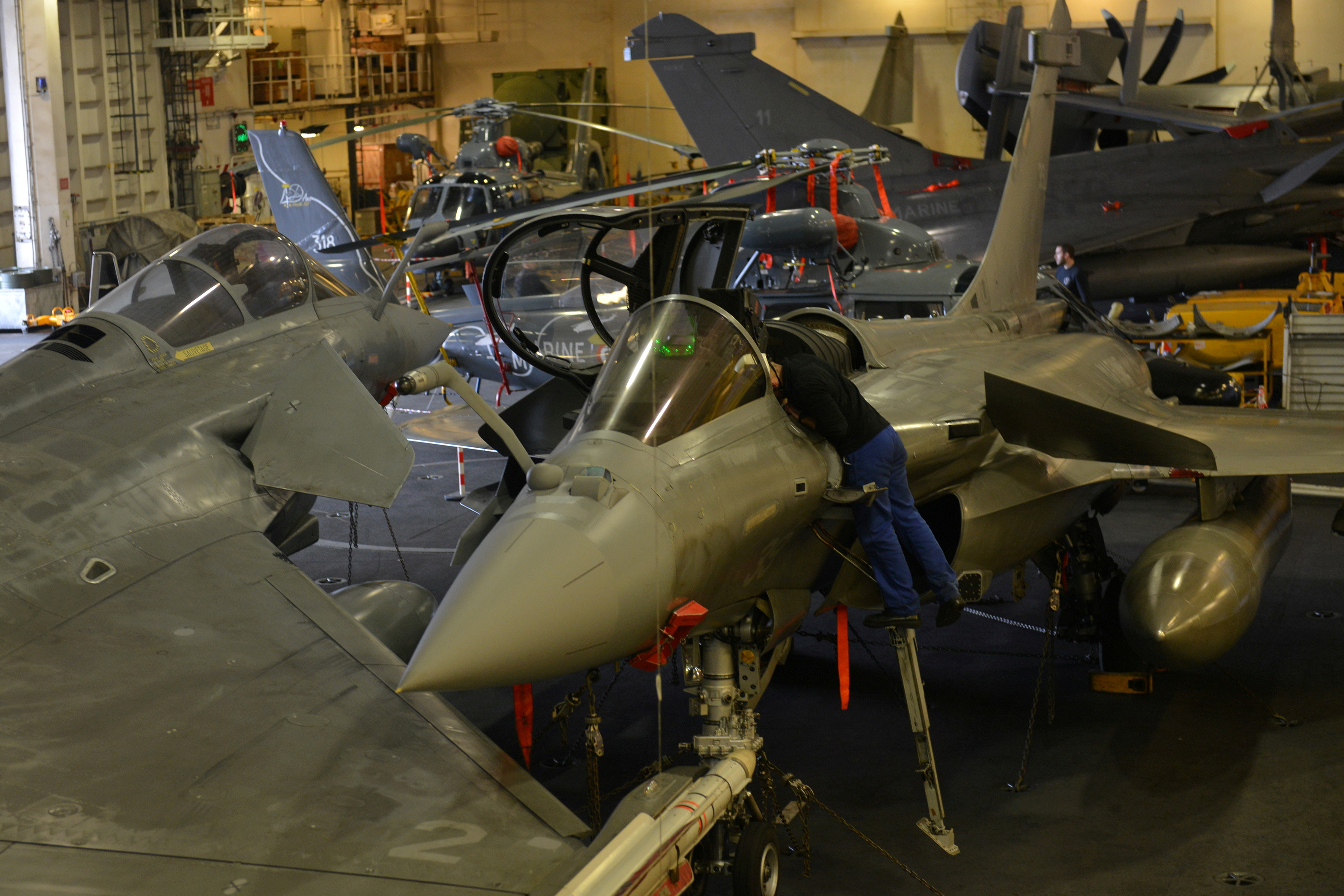 An engineer works on a French Navy Rafale fighter jet, at the hangar bay of the Charles de Gaulle aircraft carrier, currently moored at the port of Limassol, February 21, 2020. REUTERS/Stefanos Kouratzis/File Photo