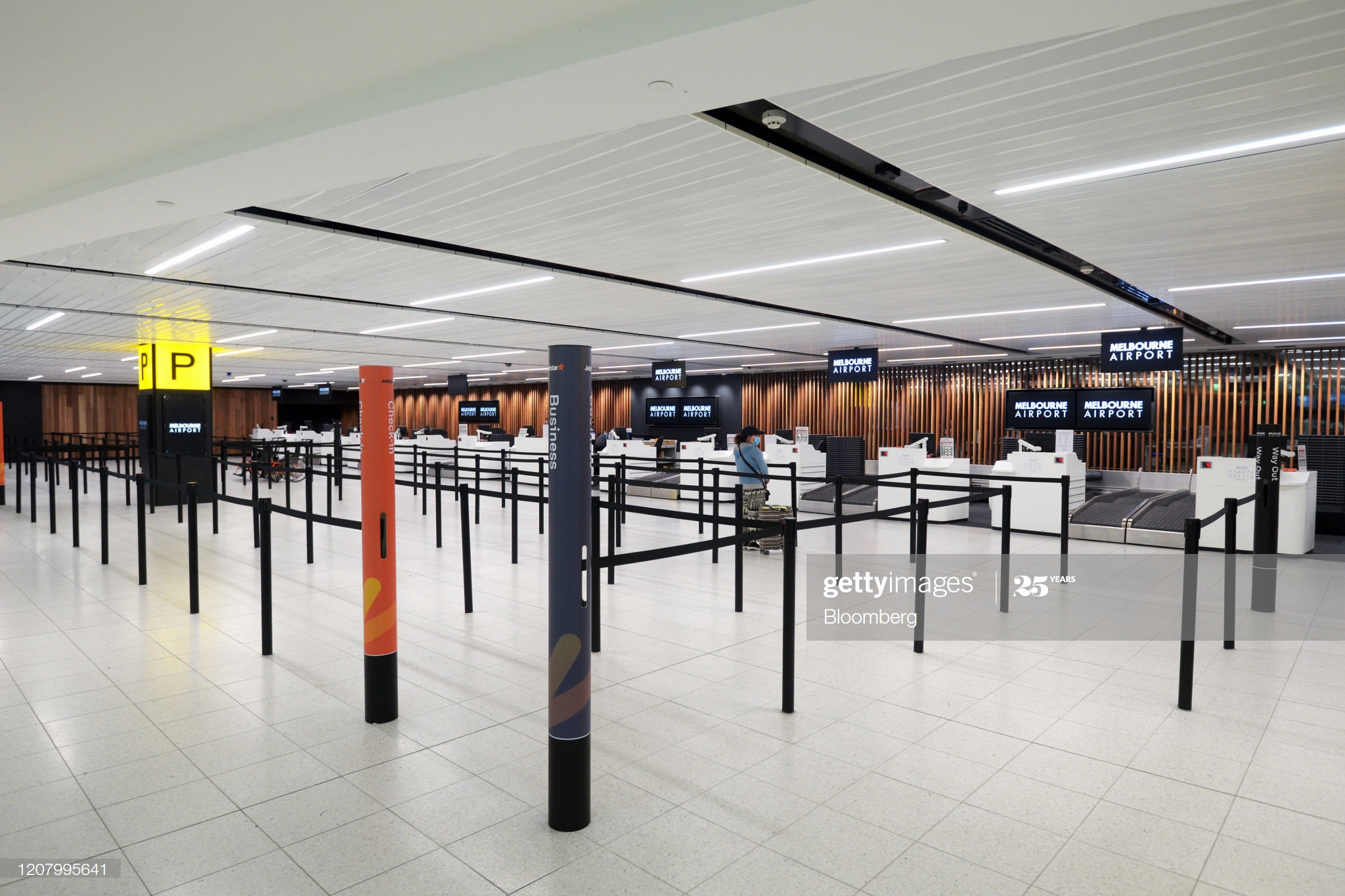 passenger-waits-beyond-checkin-lanes-at-melbourne-airport-in-on-picture-id1207995641