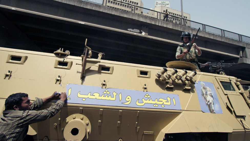 120502213221_an_egyptian_protester_rips_a_banner_on_a_military_tank_with_arabic_writing_that_reads_976x549_ap_nocredit.jpg