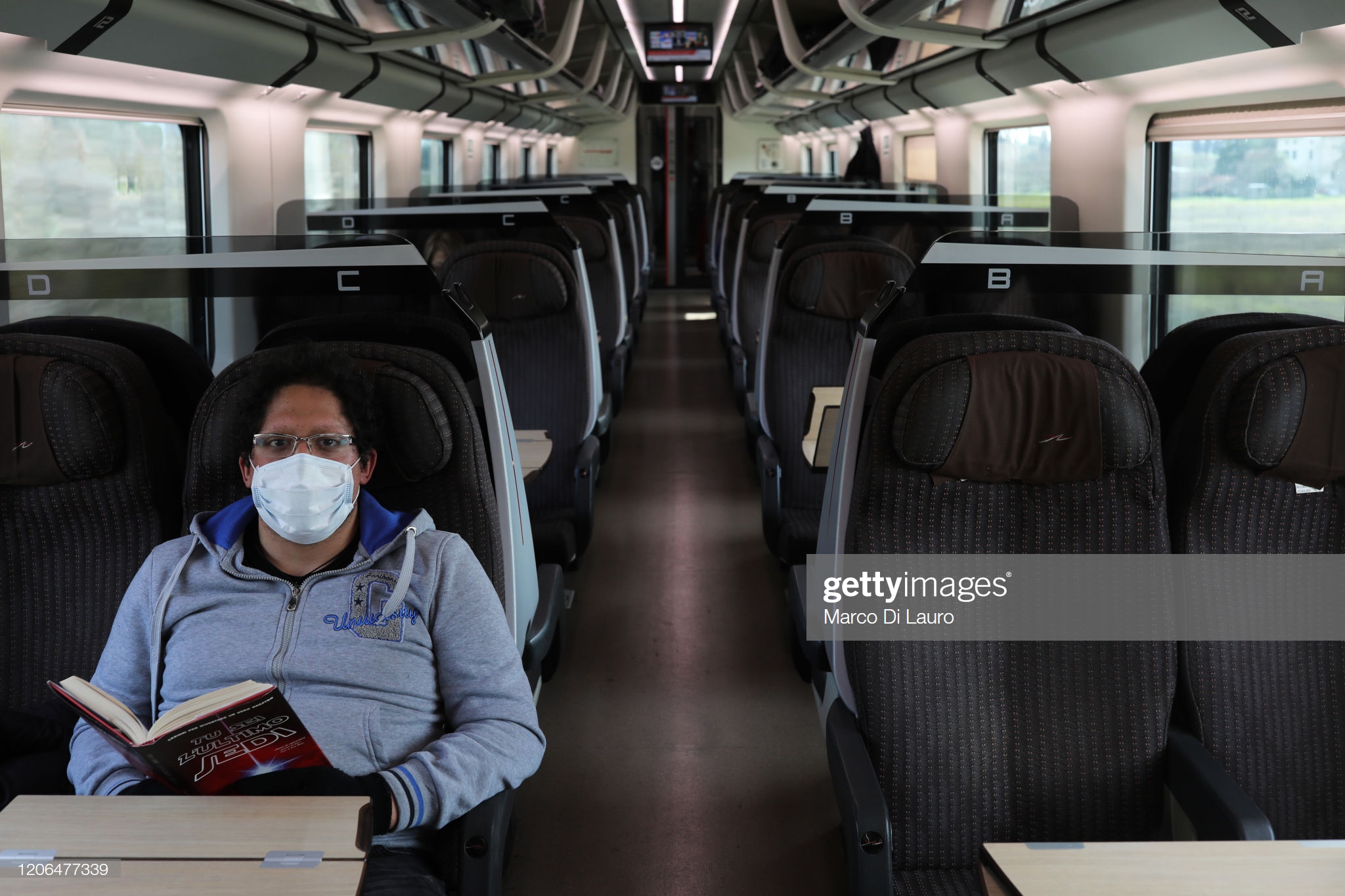 passenger-wearing-a-protective-mask-is-seen-on-the-train-leaving-the-picture-id1206477339