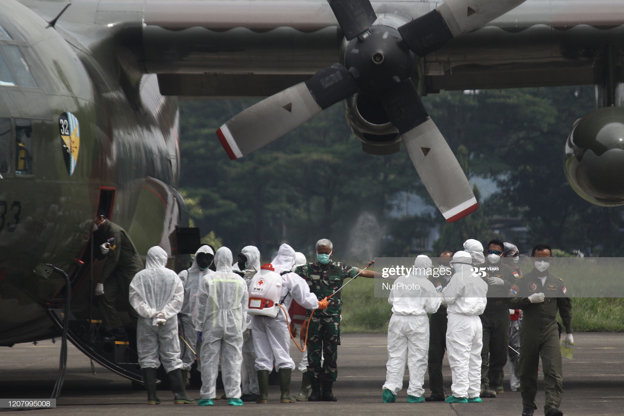 health-workers-spray-disinfectant-to-air-crews-of-c130-military-of-picture-id1207995008