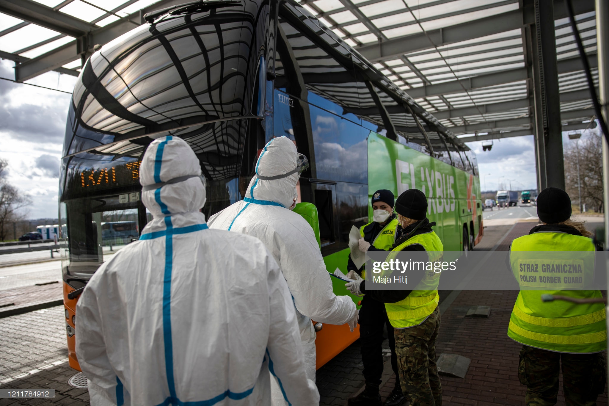 polish-border-guards-and-health-workers-wear-a-protective-mask-and-picture-id1211784912