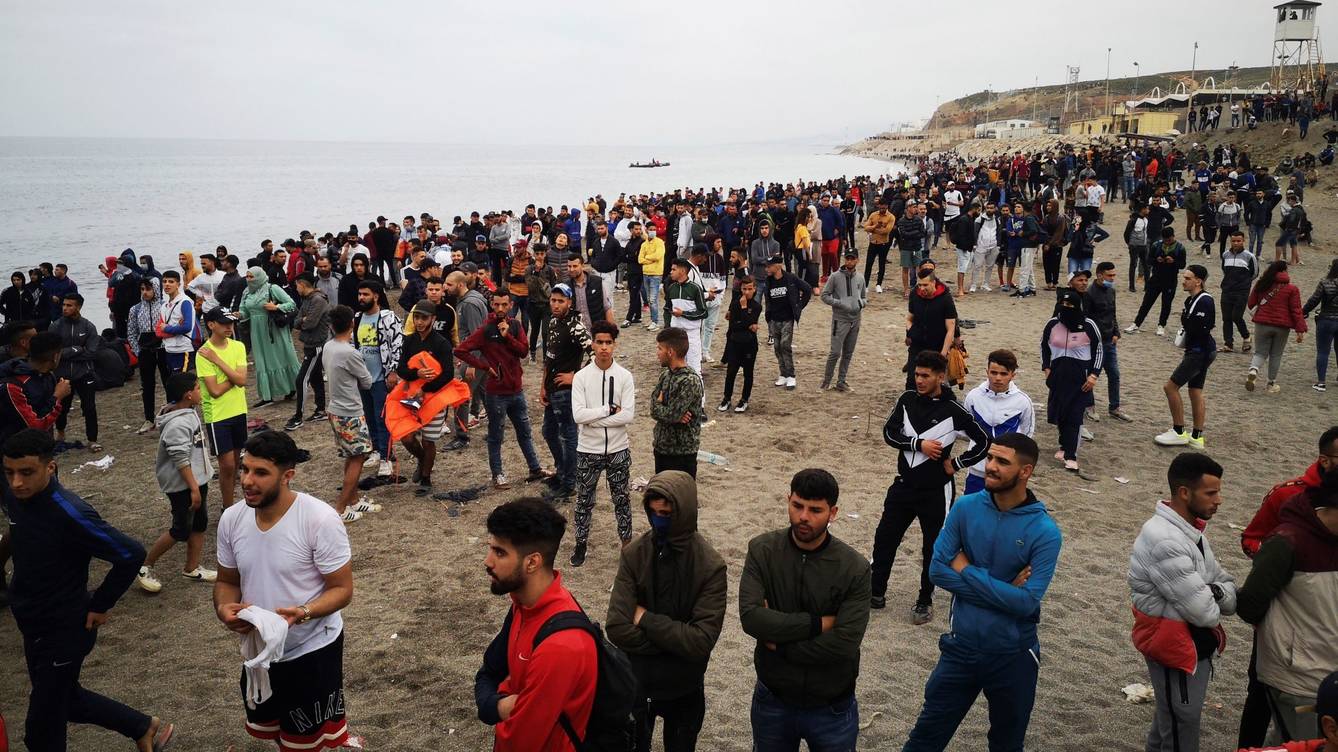 الصورة: مئات المهاجرين ينتظرون على شاطئ الفنيدق لعبور حواجز الأمواج في سبتة يوم الثلاثاء.  (EFE)