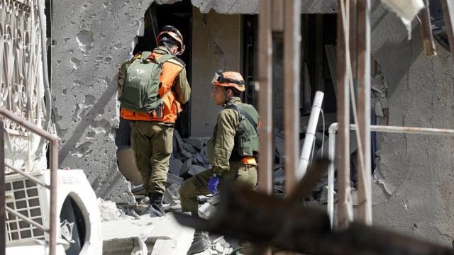 جنود إسرائيليون يتفقدون مبنى في عسقلان أصيب بصاروخ أطلق من غزة