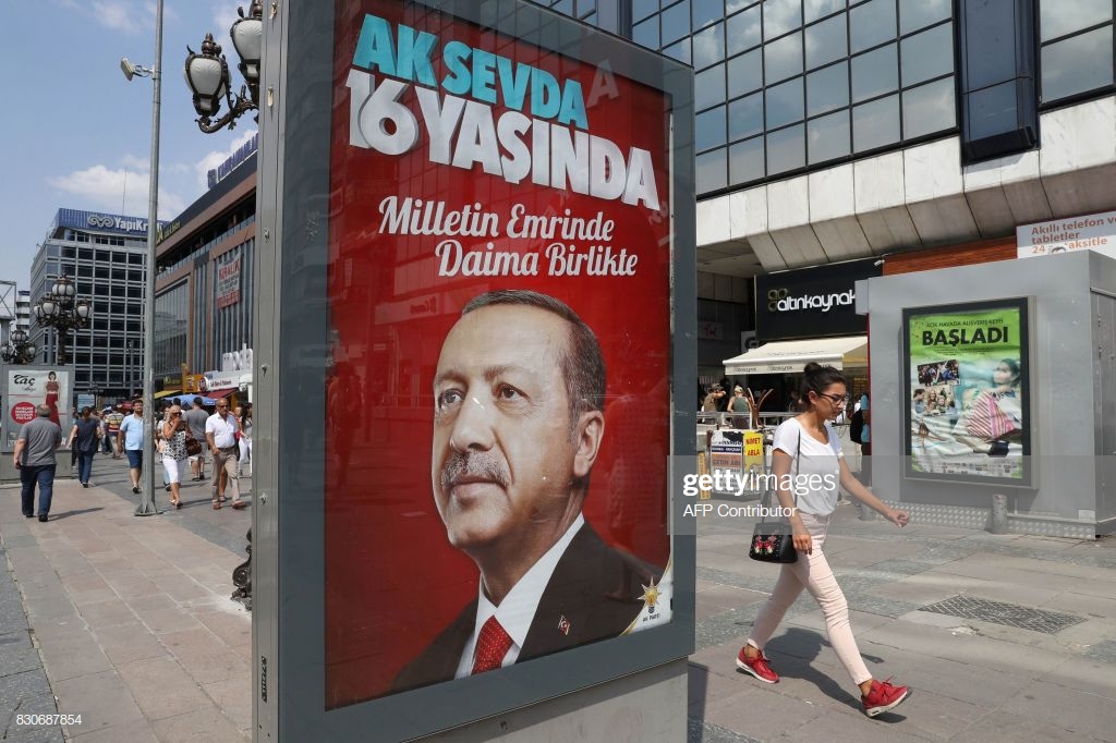 woman-passes-a-billboard-with-a-portrait-of-turkish-president-recep-picture-id830687854