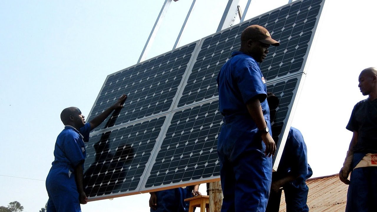 مجموعة من العمال يقومون بتثبيت ألواح للطاقة الشمسية في رواندا.
