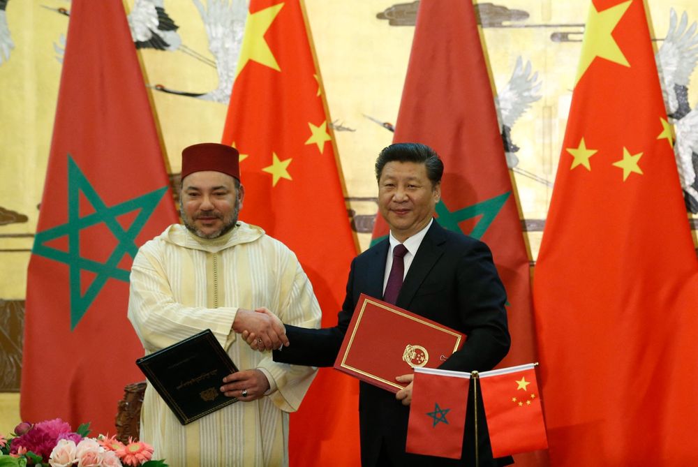 الرئيس الصيني شي جين بينغ والملك المغربي محمد السادس يتصافحان بعد التوقيع على الوثائق خلال حفل التوقيع في قاعة الشعب الكبرى في بكين في 11 مايو 2016.