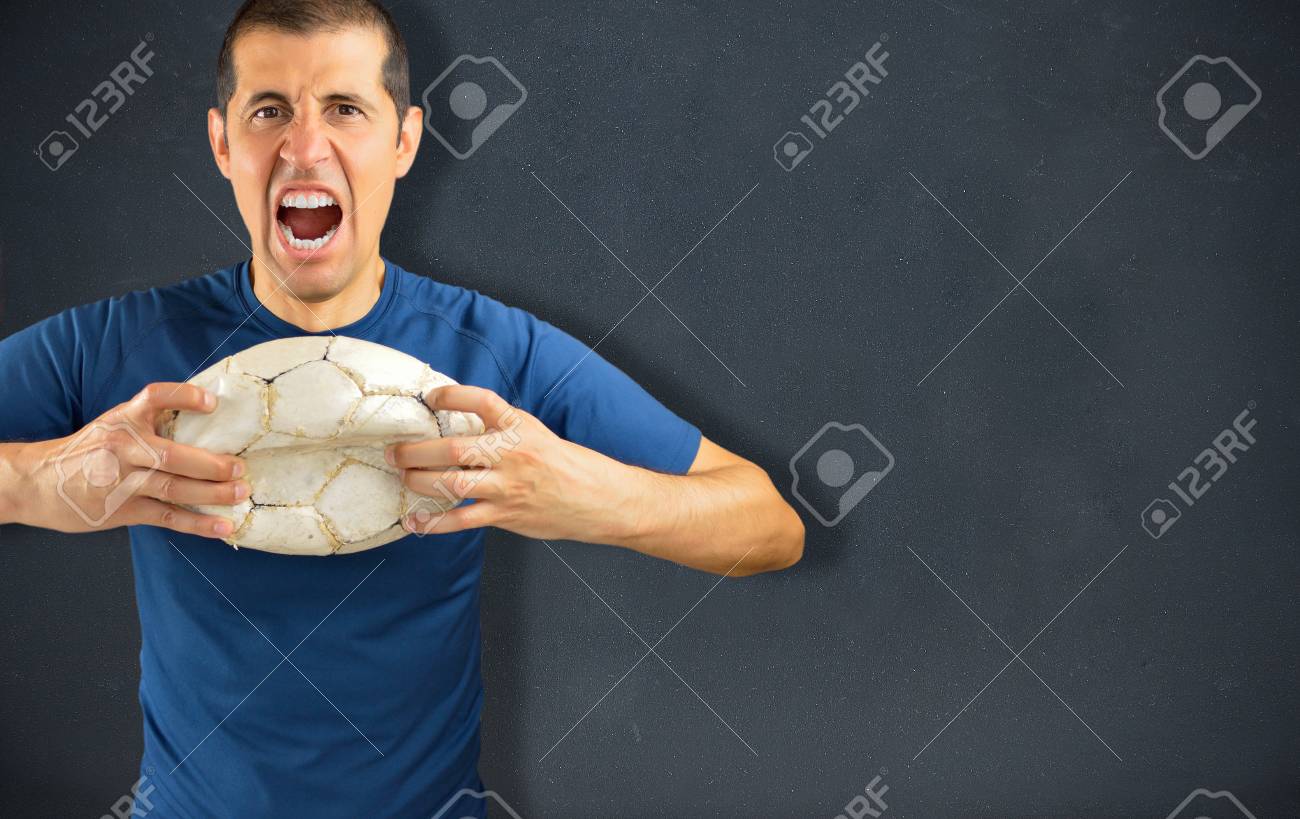 65433568-agressive-angry-loser-football-player-holding-a-broken-dirty-soccer-ball-on-blackboard-background-wi.jpg