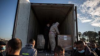 عمال فلسطينيون يفرغون شحنة لقاح Sputnik V الأولى عند وصولها إلى قطاع غزة، 21 فبراير 2021. عمال فلسطينيون يفرغون شحنة لقاح Sputnik V الأولى عند وصولها إلى قطاع غزة، 21 فبراير 2021.