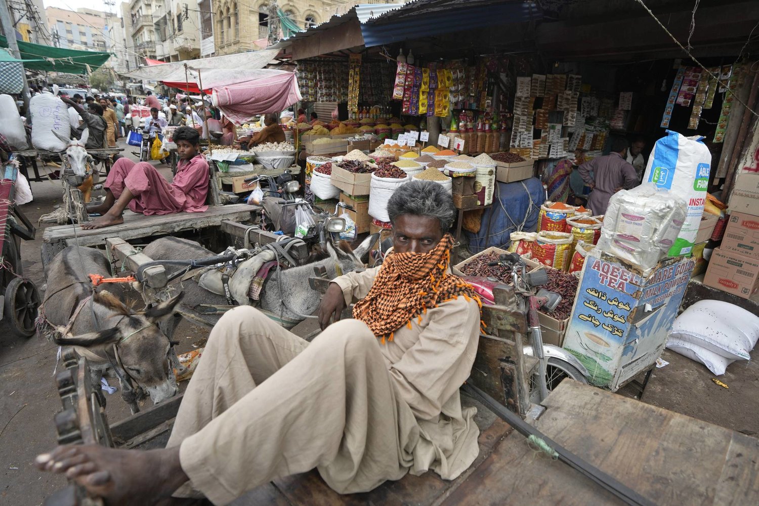 عاملون بالأجرة اليومية ينتظرون من يطلب خدماتهم وسط أحد الأسواق في كراتشي بباكستان... فيما قالت الأمم المتحدة إن 165 مليون شخص سقطوا في براثن الفقر خلال السنوات الأخيرة (أ.ب)