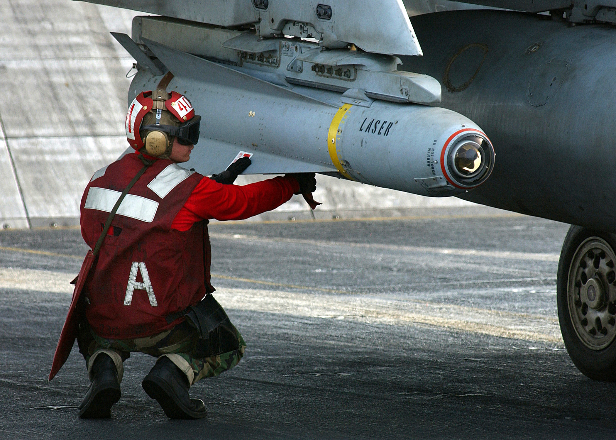 US_Navy_041128-N-5345W-016_Aviation_Ordnanceman_3rd_Class_William_Miller_arms_a_AGM-65_Maverick_laser-guided_missile.jpg